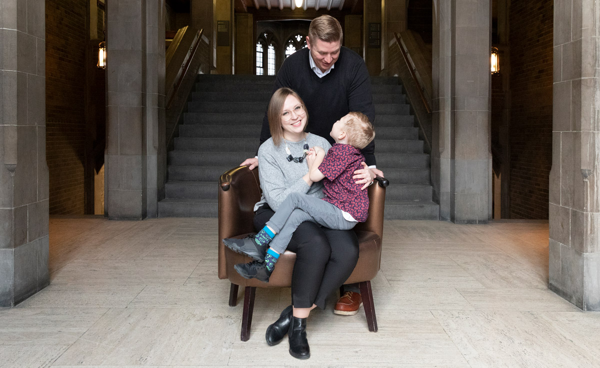 Five-year-old Will Carney sits on the lap of a smiling Katherine Carney and looks up at a smiling Adam Carney